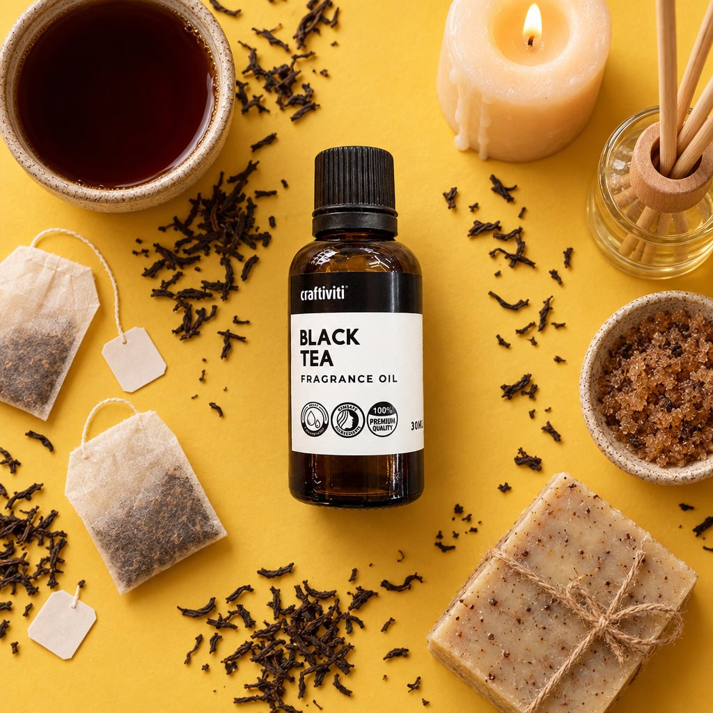 A small amber glass bottle of craftiviti Black Tea Fragrance Oil with a black cap and white label, placed on a textured beige stone surface.
