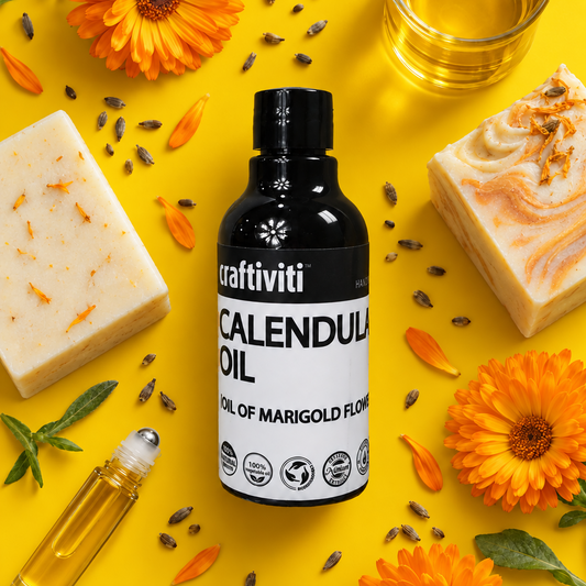 Craftiviti Calendula Oil bottle surrounded by orange marigold flowers, a glass of golden oil, soap bars, a roll-on bottle, and a dollop of white cream on a bright yellow background.