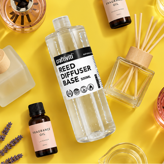 Craftiviti Reed Diffuser Base 500ml bottle in the center, surrounded by fragrance oil bottles, a reed diffuser with wooden sticks, and glass containers on a bright yellow background.