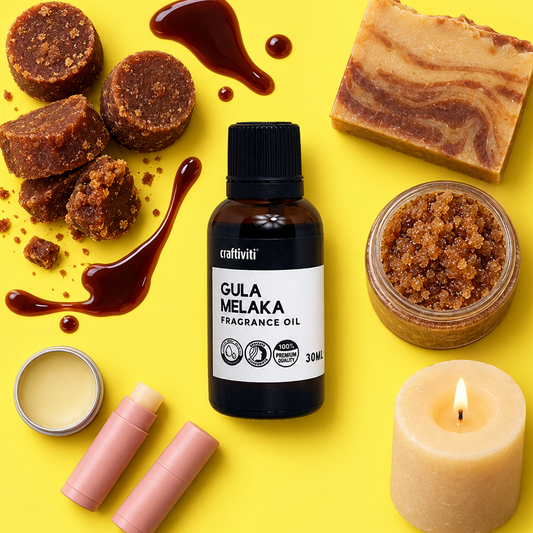 A styled flat-lay of a craftiviti Gula Melaka fragrance oil bottle surrounded by ingredients and scent-related items on a bright yellow background, including brown sugar pieces, a marbled soap bar, a jar of coarse scrub, a small candle, and two pink lip balm tubes.