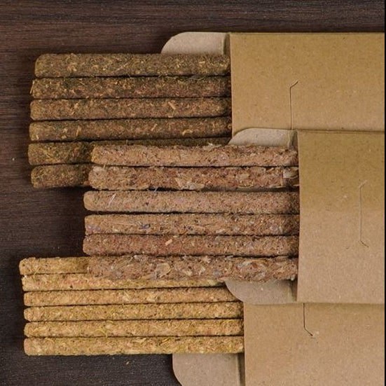 Stack of flower aromatherapy products in a cardboard box on a wooden surface